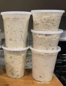 Delicious Chicken Salad in a bowl with fresh vegetables and herbs.