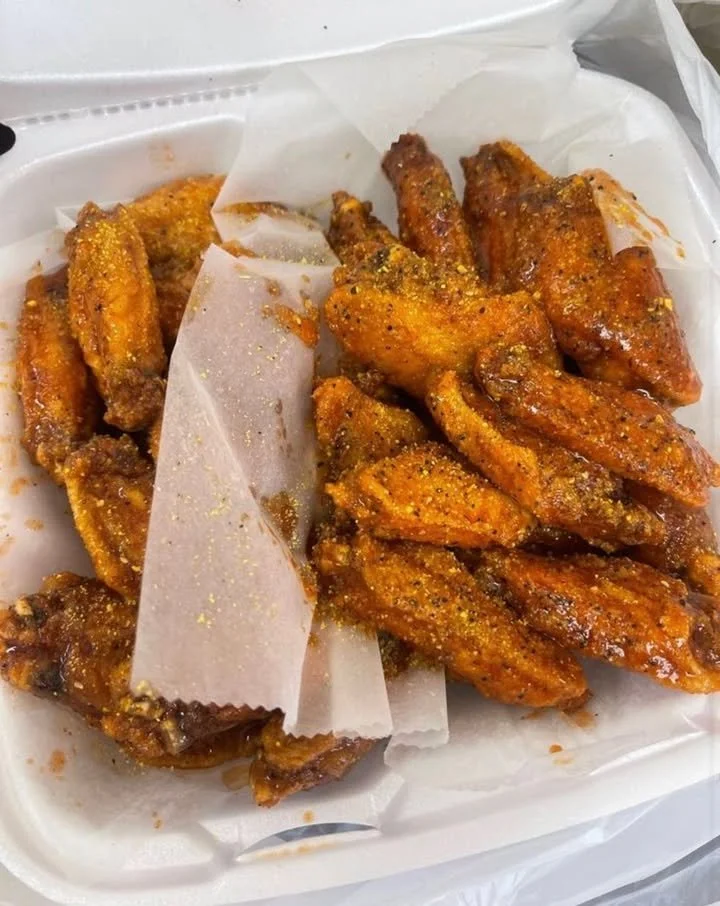 A plate of crispy chicken wings served with dipping sauce.