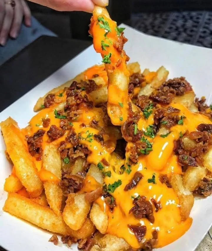 Plate of delicious Chili Cheese Fries topped with chili and melted cheese