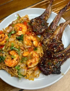 Delicious plates of chops and shrimp noodles served with fresh herbs and spices