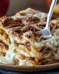 Cinnamon roll apple lasagna layered with apples and cinnamon rolls.