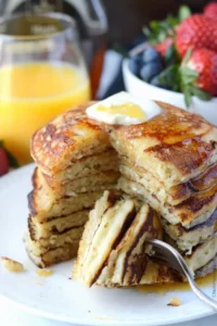 Fluffy copycat IHOP pancakes stacked on a plate with syrup drizzle