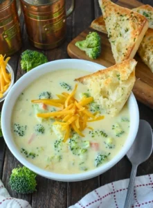 Bowl of copycat Panera broccoli cheese soup garnished with fresh herbs