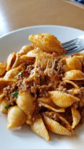 Creamy beef and cheddar pasta shells topped with herbs