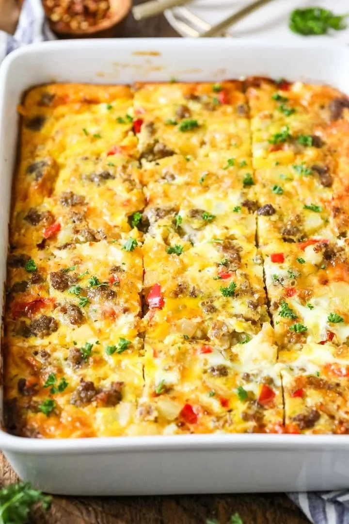 Delicious creamy burrito casserole topped with cheese and fresh ingredients.