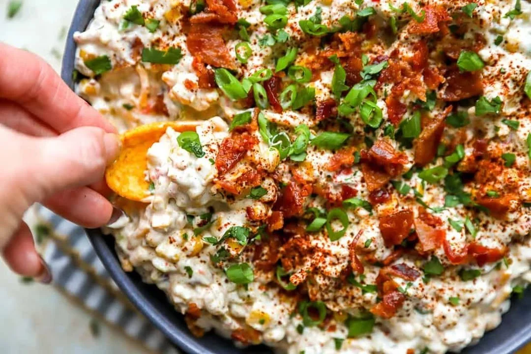 Creamy crack corn dip served in a bowl with chips