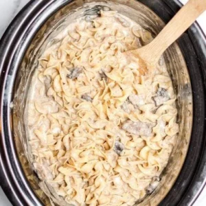 Creamy crockpot beef stroganoff served in a bowl with parsley garnish