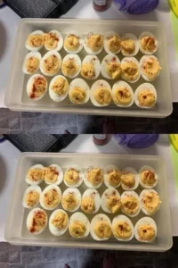 Plate of creamy deviled eggs garnished with paprika and herbs