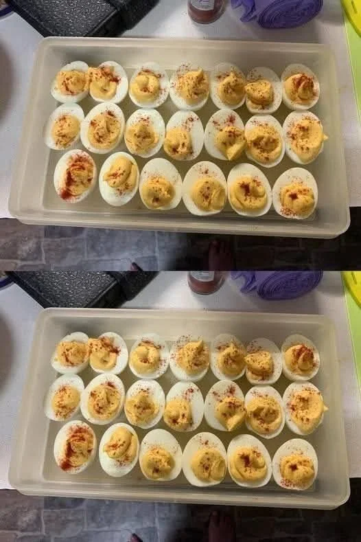 Plate of creamy deviled eggs garnished with paprika and herbs
