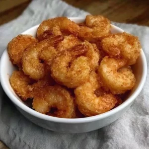 Plate of crispy fried shrimp garnished with lemon and dipping sauce