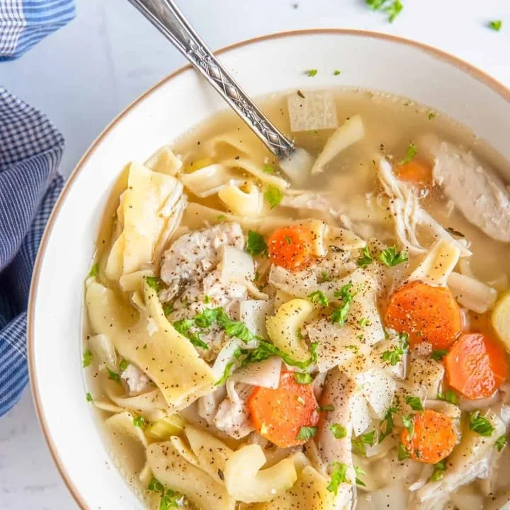 Crockpot Chicken Noodle Soup in a bowl with fresh herbs