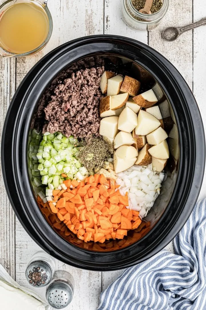 Crockpot Creamy Potato and Hamburger Soup served in a bowl with fresh ingredients.