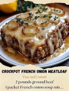 Crockpot French onion meatloaf with melted Swiss cheese, served on a plate.