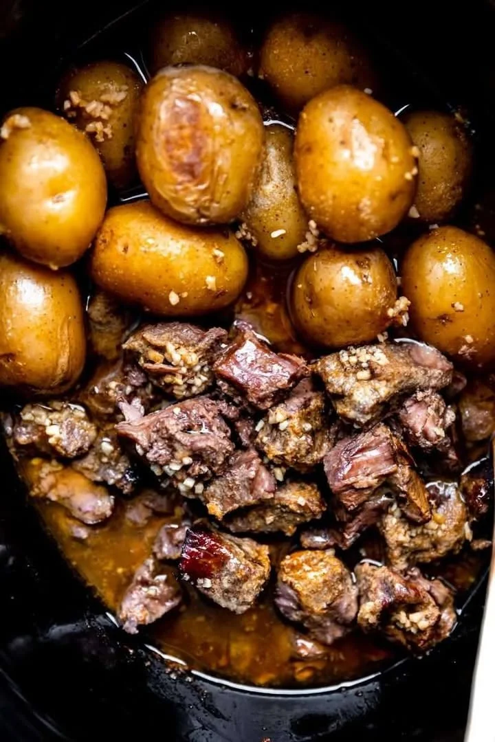 Crockpot garlic butter beef bites with potatoes served in a bowl