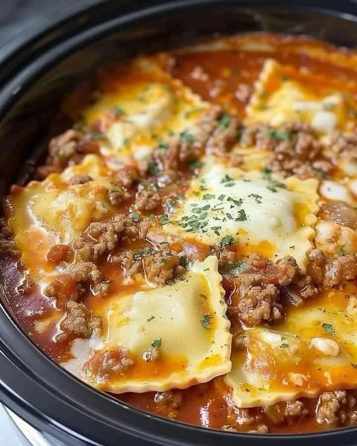 Crockpot Ravioli Lasagna ready to serve with layers of cheese and sauce.