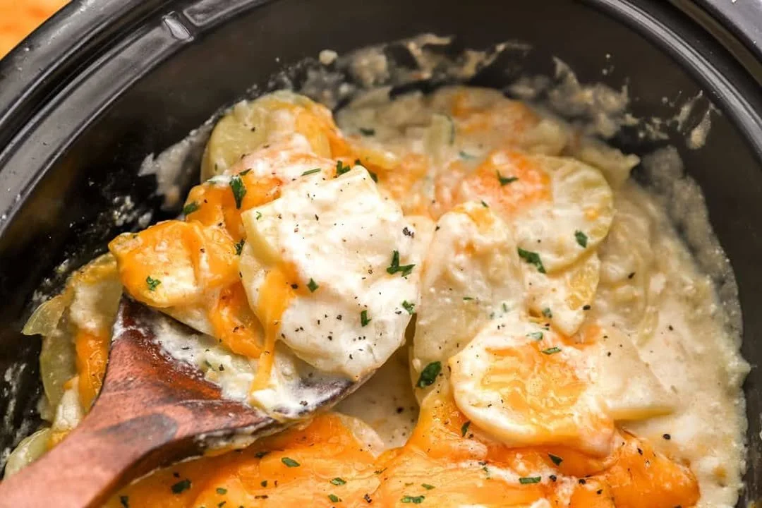 Delicious Crockpot scalloped potatoes topped with cheese and herbs.