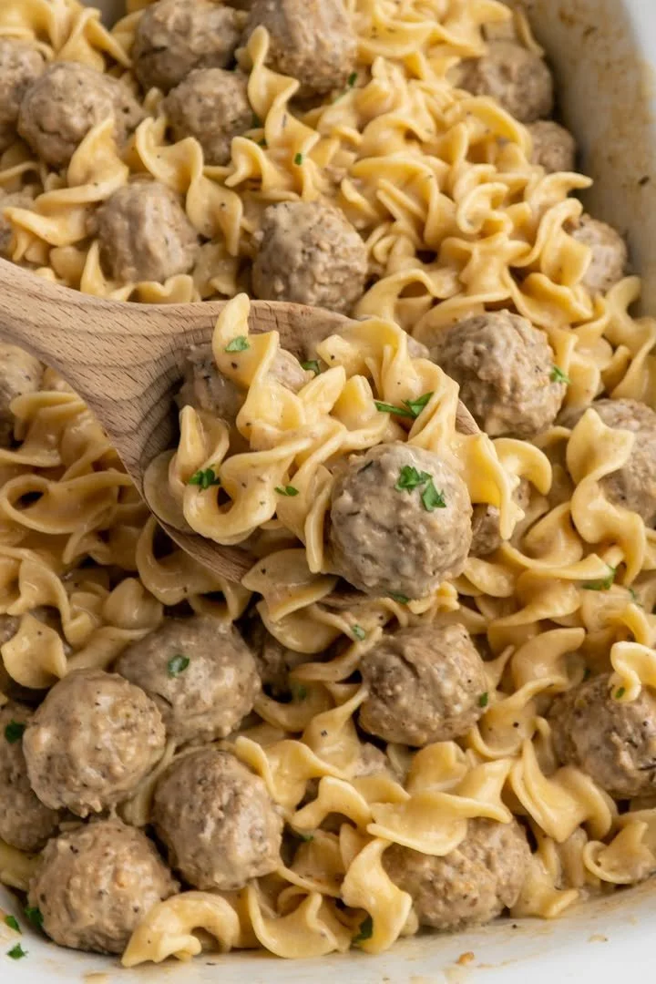 Crockpot Swedish meatball pasta served in a bowl with garnishes.