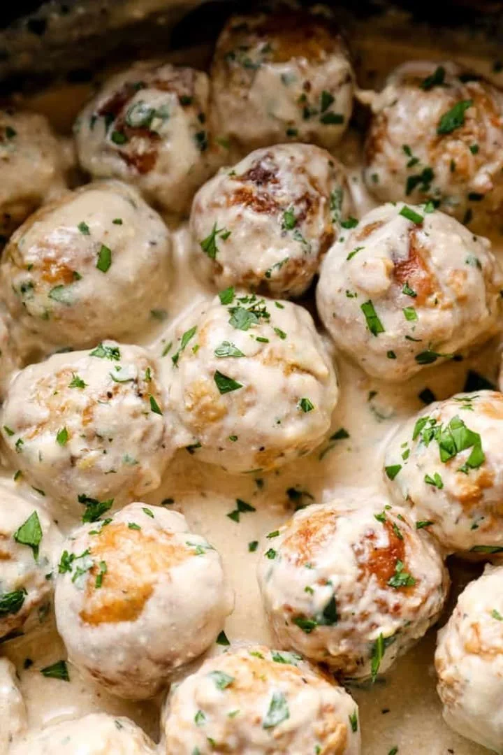 Crockpot Swedish meatballs served with gravy and parsley garnish
