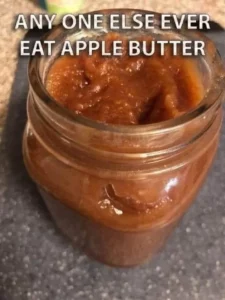 Homemade easy apple butter in a jar with fresh apples and spices