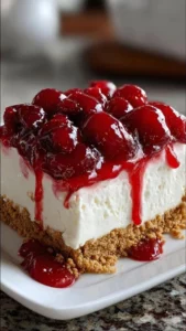 Delicious no-bake cherry cream cheese dessert topped with cherry sauce.