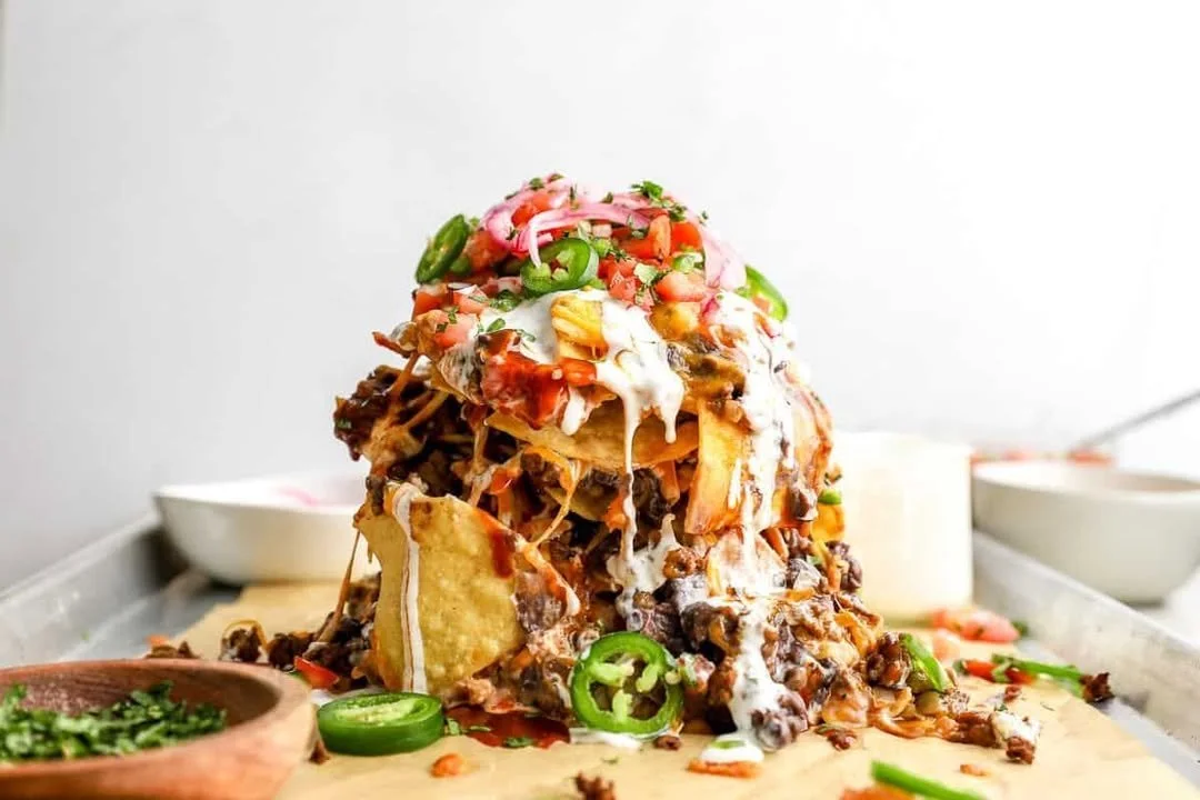 Plate of easy trash can nachos topped with cheese, jalapeños, and guacamole