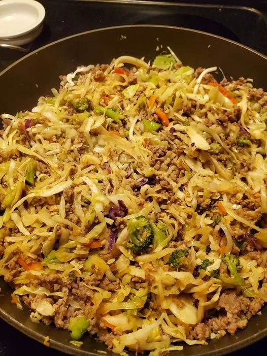 Bowl of eggroll ingredients with vibrant vegetables and savory meat