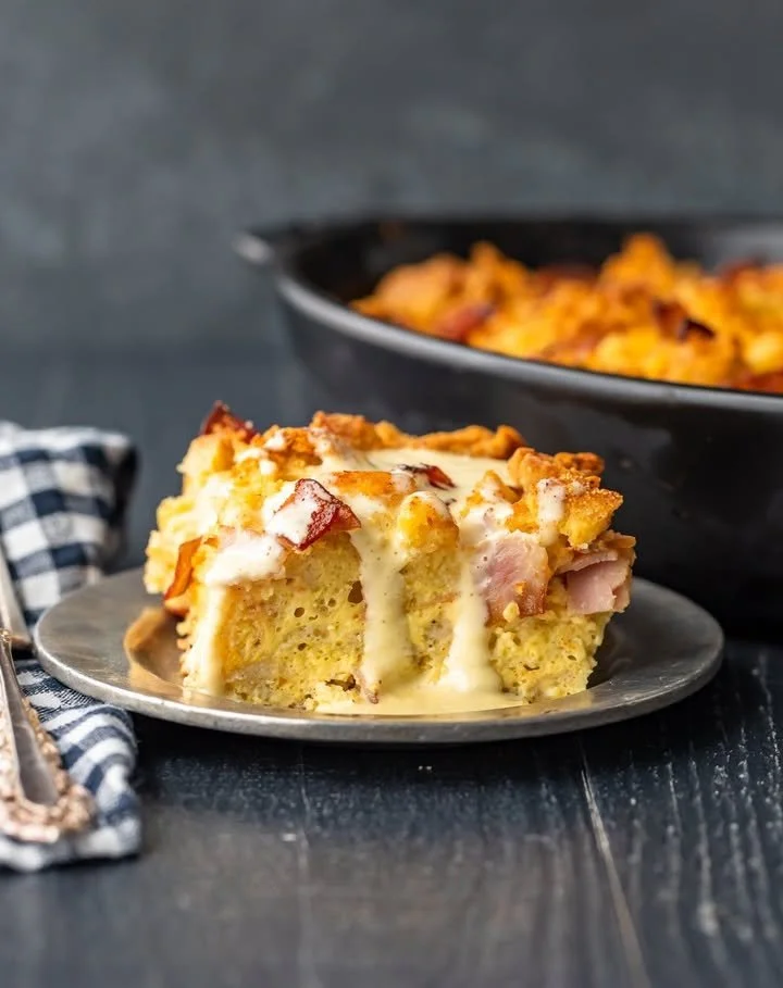 Delicious Eggs Benedict Casserole topped with hollandaise sauce and fresh herbs
