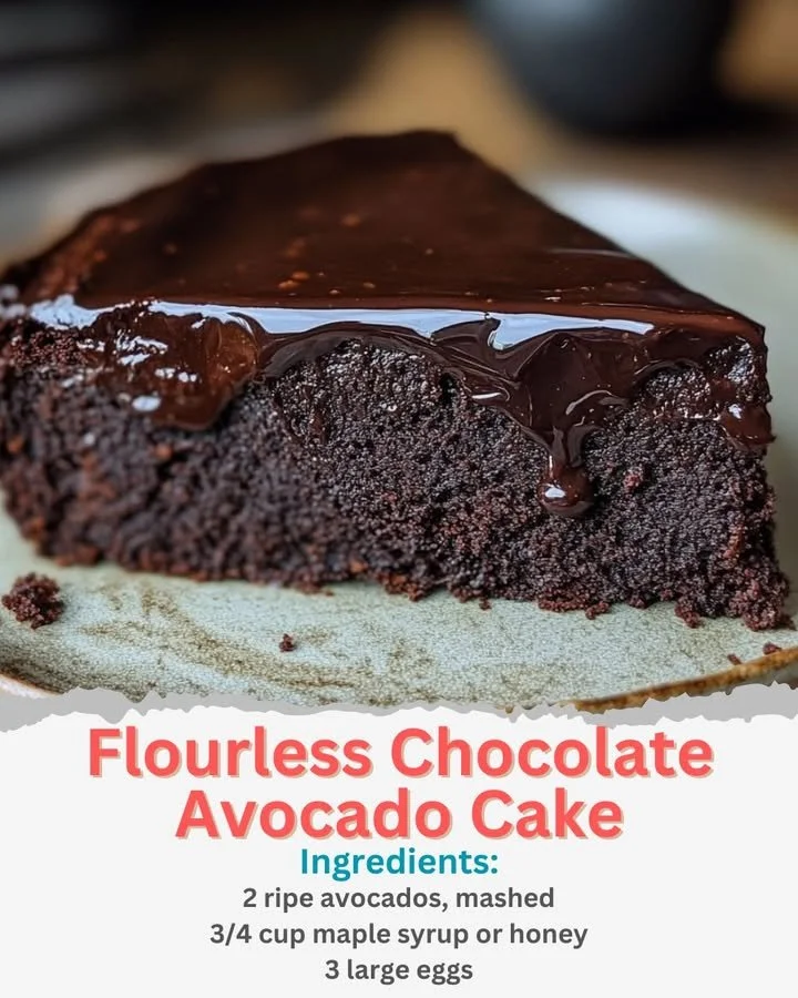 Flourless chocolate avocado cake garnished with berries and mint leaves.