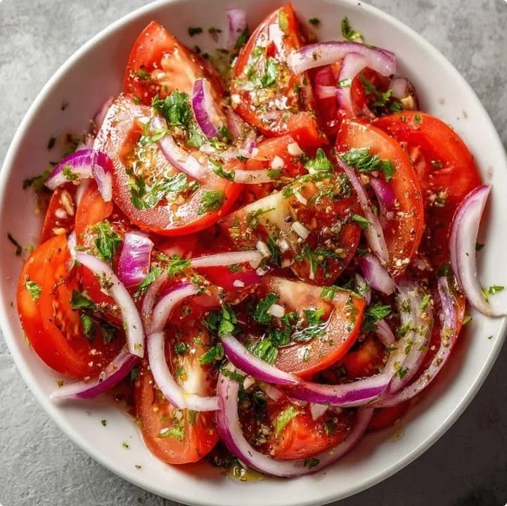 Fresh tomato and red onion salad with herb vinaigrette in a bowl