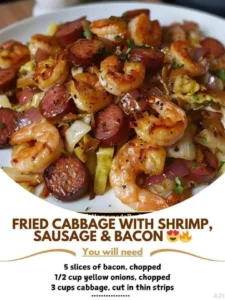 Plate of Fried Cabbage with shrimp, sausage, and bacon, garnished with herbs.