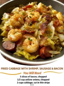 Plate of fried cabbage with shrimp, sausage, and bacon served in a skillet.