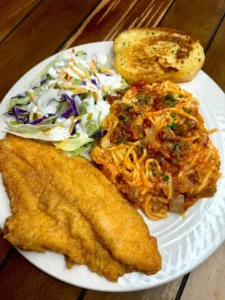 Crispy fried catfish served on a plate with a side of spaghetti
