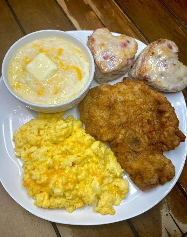 Delicious fried pork chops served with strawberry buttermilk biscuits for breakfast.