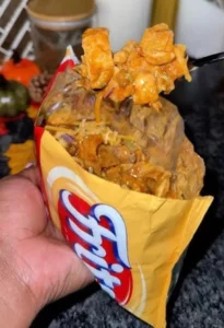 Delicious Frito Pie topped with cheese and toppings served in a bowl.