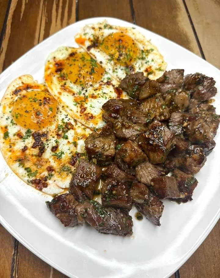Delicious Garlic Butter Steak Bites served with fried eggs and chili oil.