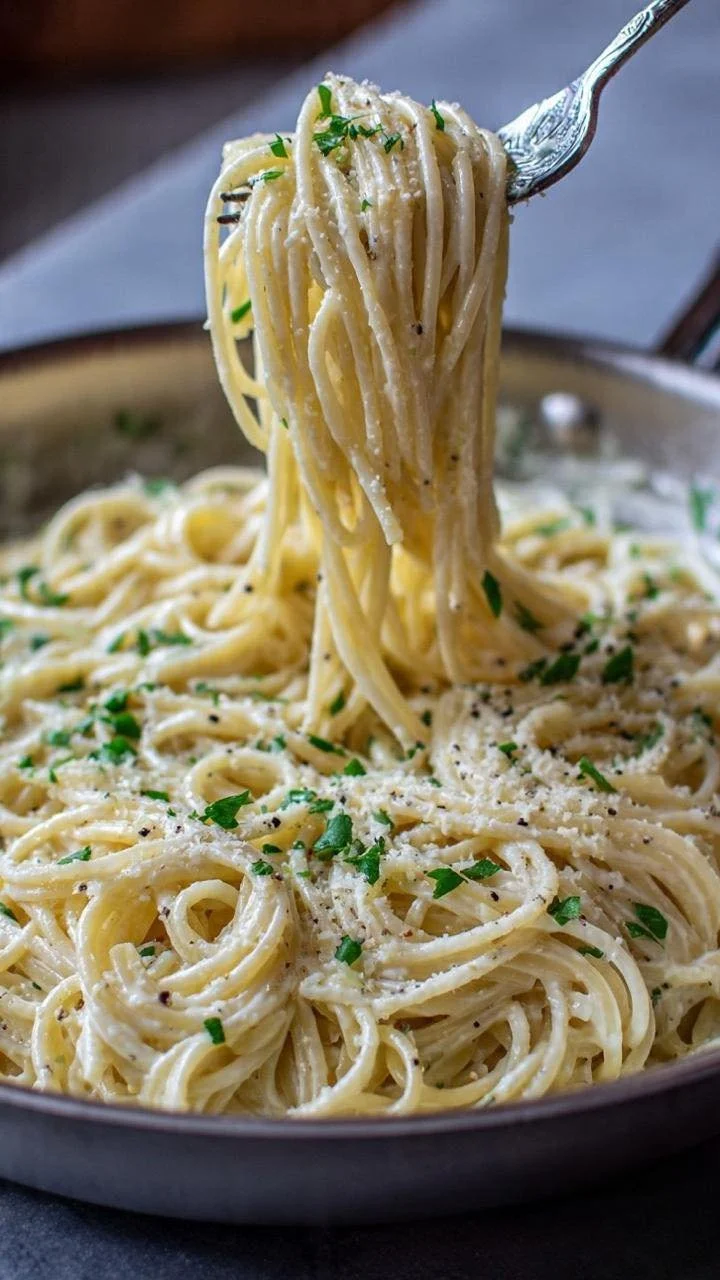 Bowl of creamy garlic parmesan pasta topped with fresh parsley and grated cheese