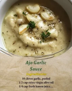 A bowl of creamy garlic sauce with fresh garlic cloves nearby