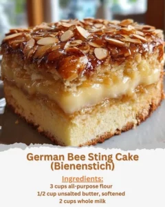 A slice of German Bee Sting Cake topped with almonds and honey cream.