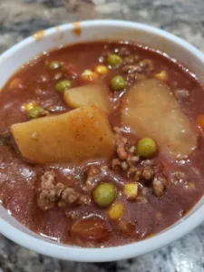 Bowl of homemade Grandma's Hamburger Soup, filled with vegetables and ground beef.