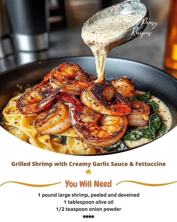 Plate of grilled shrimp with creamy garlic sauce served over fettuccine pasta