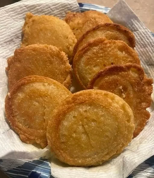 Plate of hot water cornbread served alongside a bowl of chili