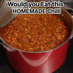 A large pot filled with delicious homemade chilli on a kitchen stove.