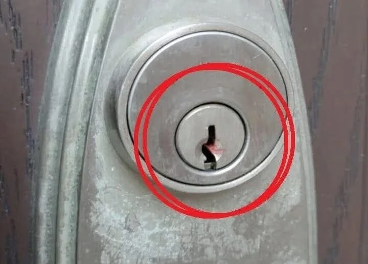 Red wax on a front door lock with concerns about safety and meaning.