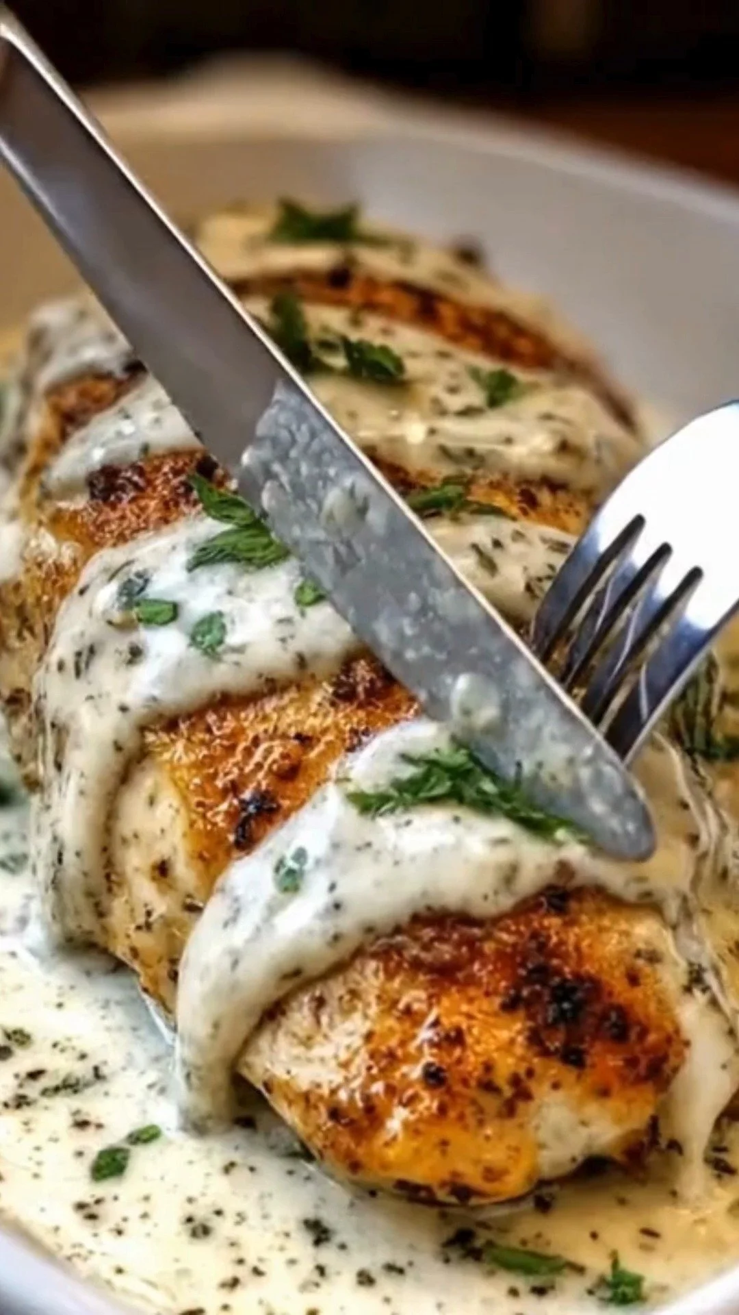 Delicious Juicy Baked Caesar Chicken served on a plate with fresh greens.