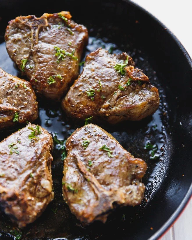Deliciously cooked lamb loin chops on a plate garnished with herbs