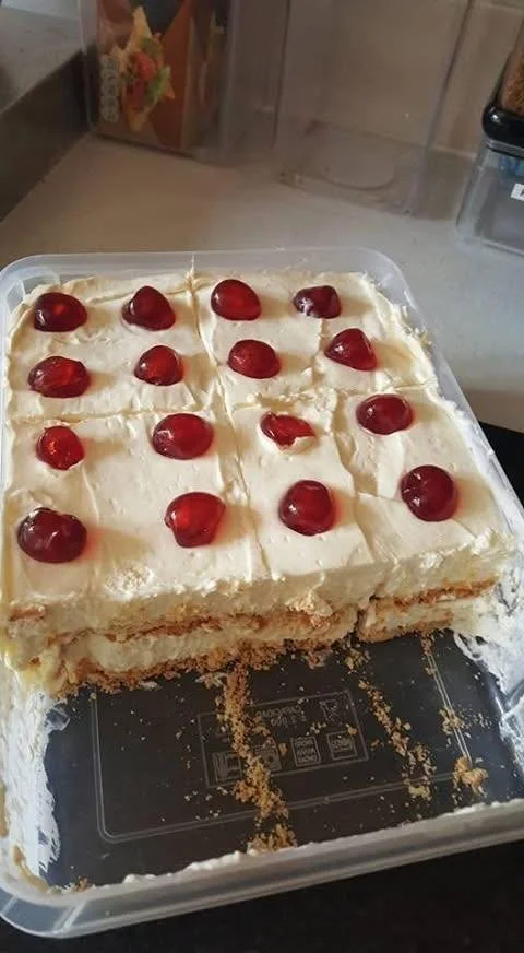Lemon tart topped with tennis biscuits on a decorative plate