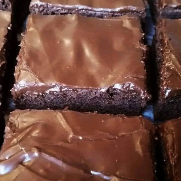 Decadent Lunchroom Ladies brownies stacked on a plate, perfect for sharing.