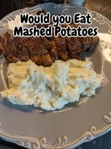 Creamy mashed potatoes served in a bowl with a pat of butter on top.