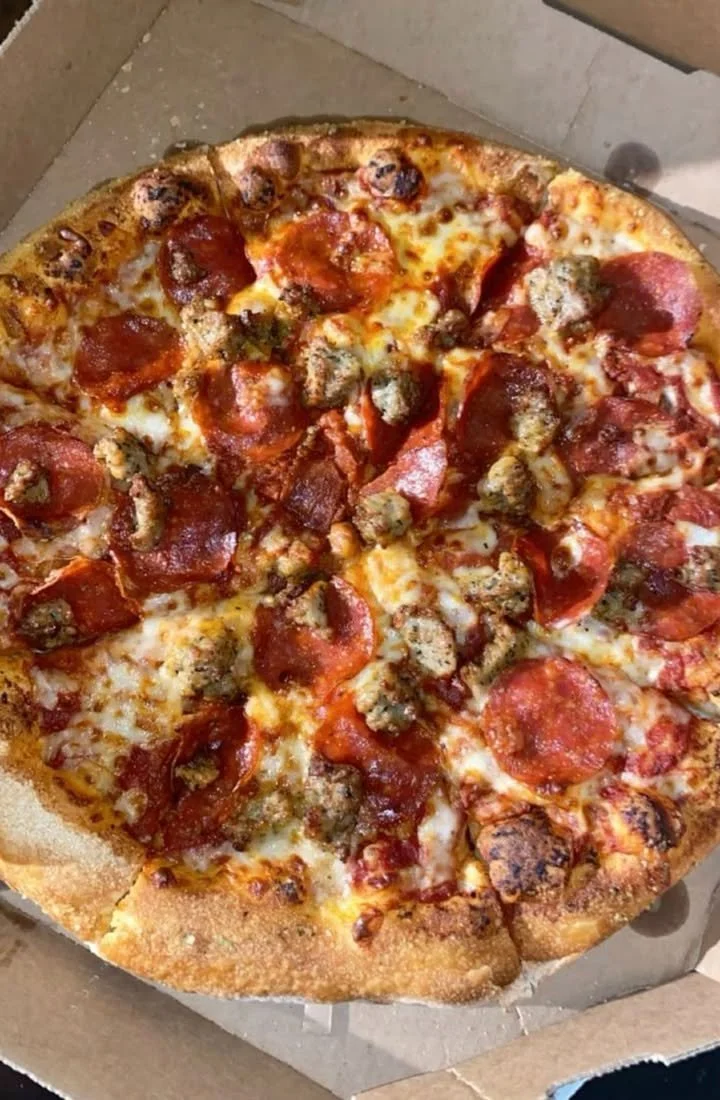 Delicious Meat Lovers Pizza topped with various meats and fresh ingredients.
