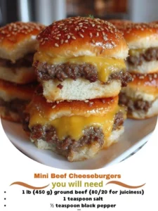 Mini beef cheeseburgers served on a platter with toppings.
